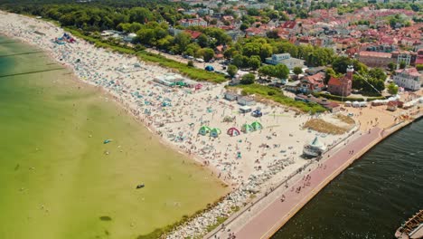 Playa-Soleada-Llena-De-Turistas-Bañándose-Vista-Desde-Un-Dron