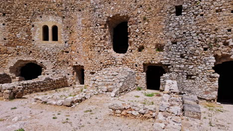 Panning-shot-of-rock-walls-of-Medieval-Chlemoutsi-castle-in-Kastro-village,-Peloponnese,-Kyllini-Andravida,-Greece-on-a-sunny-day