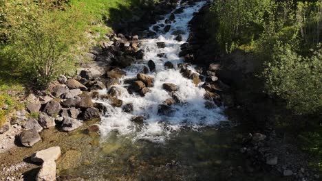 Agua-Corriendo-Sobre-Rocas-De-Guijarros-En-Walensee,-Suiza