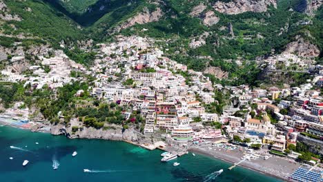 Rotierende-Luftaufnahme-über-Positano:-Grüne-Berggipfel,-Azurblaues-Wasser,-Farbenfrohe-Küstenhäuser-Und-Boote-–-Amalfiküste,-Italien