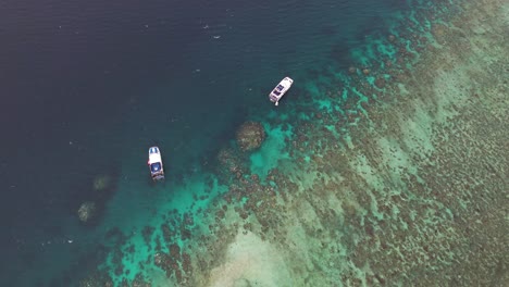 Vista-Aérea-A-Vista-De-Pájaro-De-Barcos-En-La-Gran-Barrera-De-Coral,-El-Sistema-De-Arrecifes-De-Coral-Más-Grande-Del-Mundo,-Australia