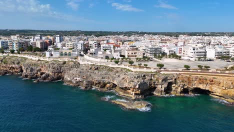 Aerial-Perspective-Of-A-Jagged-Seashore,-Azure-Waters,-In-Polignano-A-Mare,-Italy