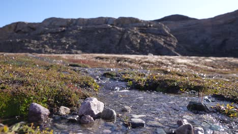 Water-Outflow-From-Natural-Spring-in-Landscape-of-Greenland-on-Sunny-Winter-Day