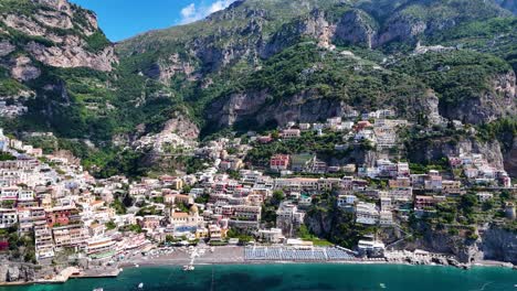 Cinematic-Aerial-Reveal-Of-Positano,-Tall-Mountains,-Tyrrhenian-sea,-Boats,-Amalfi-Coast,-Italy