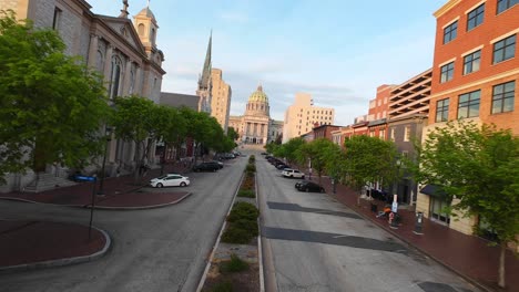 Drone-FPV-Disparado-Sobre-State-Street-En-El-Centro-De-Harrisburg,-Revelando-El-Edificio-Del-Capitolio-Del-Estado-De-Pensilvania-Durante-La-Puesta-De-Sol-De-La-Hora-Dorada