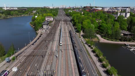 Aerial-Tracking-Shot-Above-Commuter-Trains-in-Helsinki,-Finland