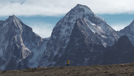 Aerial-drone-footage-of-a-trekker-running-on-Everest-Base-Camp-trek-in-Nepal,-enjoying-the-majestic-mountain-views-after-a-successful-hike