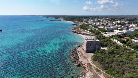 Aerial-View-Over-A-Beach-With-Turquoise-Water-With-Torre-Specchia-Ruggeri-Below-In-Puglia,-Italy