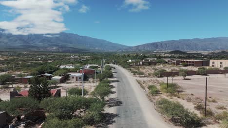 Aerial-Drone-Shot-of-Small-Town-Road-Leading-Through-Empty-Town-in-Hot-Dry-Arid-Desert-Mountain-Region