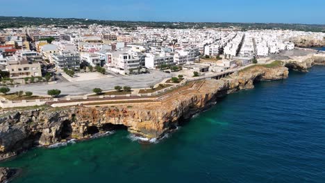 Revelación-Aérea-Gradual-De-La-Costa-Rocosa-De-Puglia-Con-Una-Visión-De-Polignano-A-Mare,-Italia.