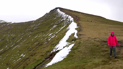 Frau-Wandert-An-Einem-Kalten-Tag-Entlang-Des-Schneebedeckten-Corn-Du-Mountain-Im-Brecon-Beacons-Nationalpark,-Wales