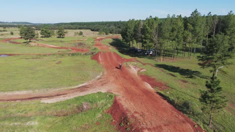 Motocross-rider-rides-a-mud-track-in-a-lush-forest-area