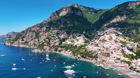 Drone-View-Over-Positano,-Surrounded-By-Tall-Mountains,-Turquoise-Water-and-Boats,-Amalfi-Coast,-Italy