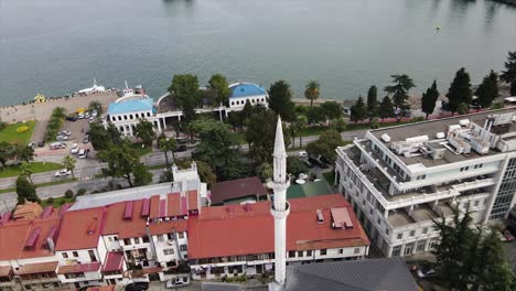 Aerial-shot-of-Batumi-Mosque-close-by-the-coast-of-the-black-sea-with-road-and-cars-passing-by