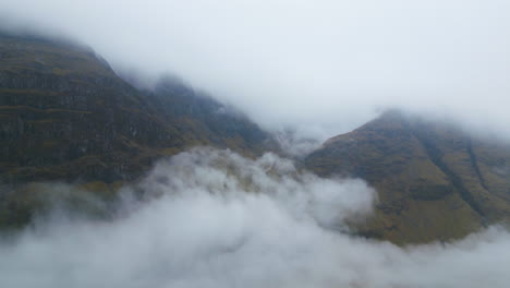 Mountain-Peaks-Covered-in-Clouds-with-Valley-Fog---Eerie-Aerial-View