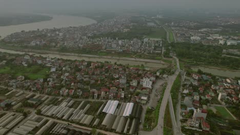 Aerial-view-of-Hanoi,-Vietnam,-showcasing-a-blend-of-urban-and-agricultural-areas-with-a-river-winding-through-the-city