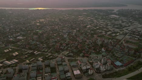 Abendlicher-Panoramablick-Aus-Der-Luft-Auf-Hanoi,-Vietnams-Wohngebiet-In-Der-Nähe-Des-Flusses,-Der-Das-Konzept-Eines-Ruhigen-Stadtlebens-Und-Malerischer-Gemeinden-Am-Flussufer-Veranschaulicht