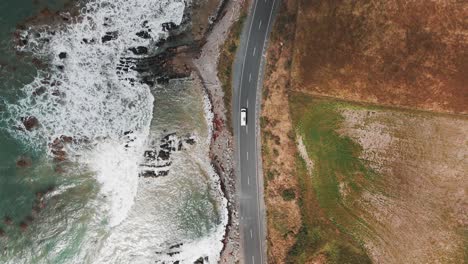 Toma-De-Drone-De-Una-Camioneta-Conduciendo-A-Lo-Largo-Del-Océano-En-La-Bahía-De-Molyneux-Cerca-De-Kaka-Point-En-La-Región-De-Otago-En-Nueva-Zelanda