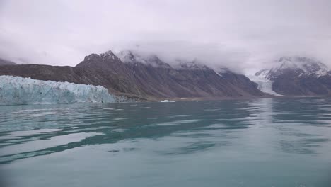 Sailing-Under-Glacier-and-Volcanic-Hills-in-Cold-Arctic-Sea,-Slow-Motion