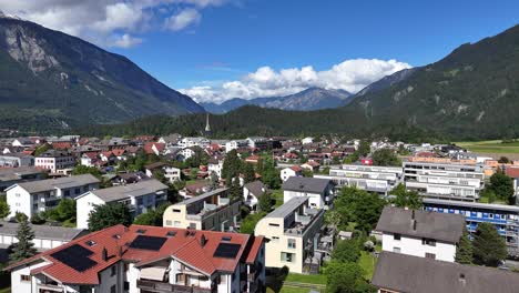 Vista-Aérea-Panorámica-De-Bonaduz,-Suiza,-Rodeada-De-Montañas-Y-Una-Vibrante-Zona-Residencial.