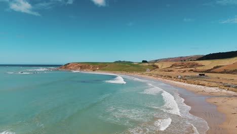 Stunning-turquoise-green-clear-waters-of-Molyneux-bay-Kaka-Point-Otago-New-Zealand,-aerial-dolly