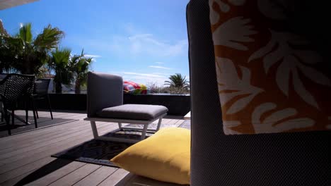 Slow-revealing-shot-of-patio-furniture-sat-in-the-sun-on-a-villas-balcony-in-Sete