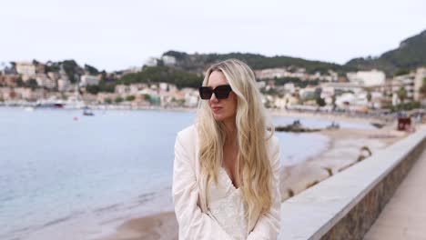 Female-Tourist-With-Blonde-Hair-Sitting-At-Promenade-In-Port-de-Soller,-Mallorca,-Spain