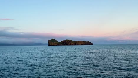 Remote-Ellidaey-island-at-Vestmannaeyjar-in-Iceland,-view-from-moving-vessel