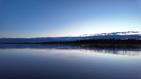 Una-Tranquila-Vista-Nocturna-De-Un-Río-Tranquilo-Con-Un-Hermoso-Reflejo-Del-Cielo-Y-Los-árboles-Al-Atardecer-En-Rusia