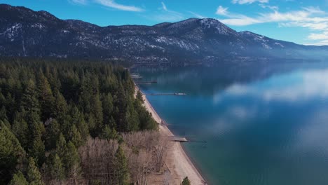 Aerial-View-of-Beautiful-Lake-Tahoe-on-Sunny-Winter-Day,-Beach-and-Conifer-Forest,-Drone-Shot