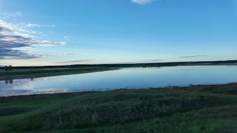 Ein-Ruhiger-See,-Der-Den-Blauen-Himmel-An-Einem-Ruhigen-Morgen-Reflektiert