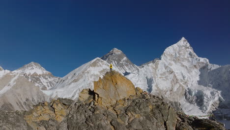 Drone-reveals-a-tourist-happily-enjoying-the-view-from-Kalapatthar-viewpoint-on-Everest-Base-Camp-trek,-Nepal