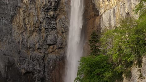 Tall-Seerenbach-Falls-plunging-down-a-rugged-cliff-face-surrounded-by-lush-greenery-in-Amden,-Betlis,-near-Walensee,-Switzerland