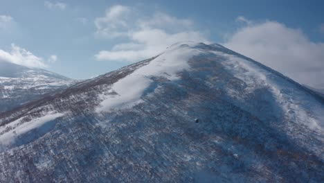 Snow-covered-mountain-peak-in-Iwanai,-Hokkaido-under-a-clear-blue-sky