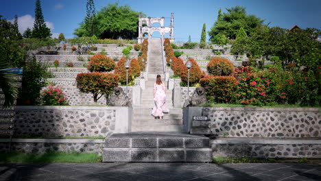 Female-travel-influencer-in-summer-dress-walk-up-stairs-of-Ujung-Water-Palace