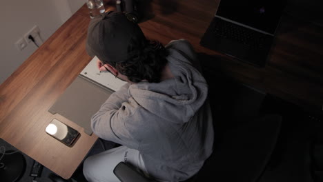 Top-down-Shot-Of-A-Young-Man-Writing-On-A-Digital-Tablet