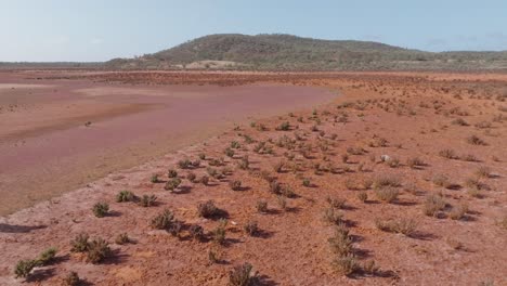 Panning-up-drone-clip-showing-male-backpacker-walking-through-remote-australian-desert-outback