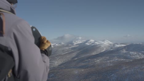 Snowboarder-at-Hokkaido's-Iwanai-resort-with-splitboard-overlooking-snow-covered-mountains