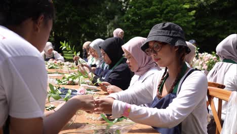 Muslimische-Frauen-Basteln-Blumenkränze-Auf-Dem-Tisch-Für-Eine-Veranstaltung