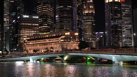 Hermoso-Puente-Jubilar-Contra-El-Impresionante-Paisaje-Nocturno-De-La-Arquitectura-Moderna-De-Los-Rascacielos-De-Singapur