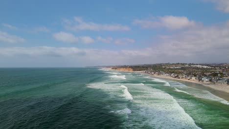 Vista-Aérea-De-Olas-Espumosas-Rodando-Hasta-La-Costa-De-La-Playa-Del-Mar-En-Verano-En-California,-Estados-Unidos