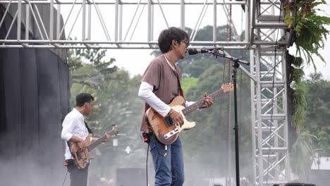 Cantante-Indonesio-Tocando-La-Guitarra-En-El-Escenario-De-Un-Concierto-Al-Aire-Libre