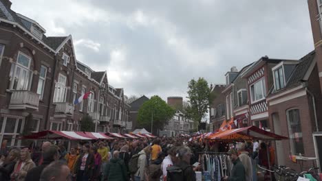 Festive-market-scene-during-King's-Day-in-Utrecht,-Netherlands,-with-bustling-crowds-and-vibrant-stalls