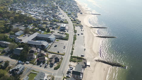 Port-of-Nantucket-in-Massachusetts-with-coastal-road,-sandy-beach-and-houses