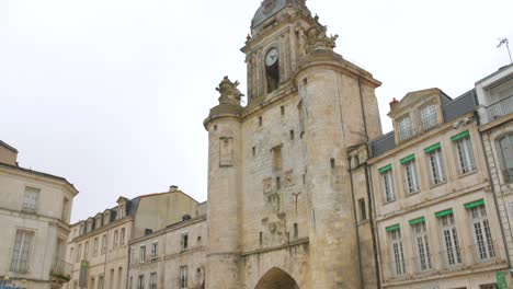 Tilt-down-shot-of-Grosse-Horloge-,-former-historic-town-door-in-La-Rochelle,-France-during-daytime