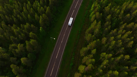 Aerial-view-tracking-a-Motorhome,-on-the-countryside-of-Finland,-summer-evening