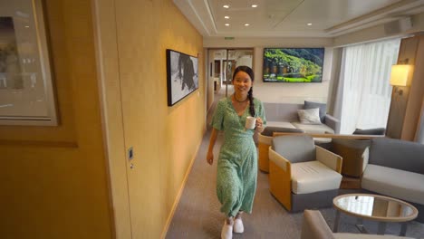 Happy-Chinese-girl-walking-with-cup-of-tea-inside-a-cruise-ship