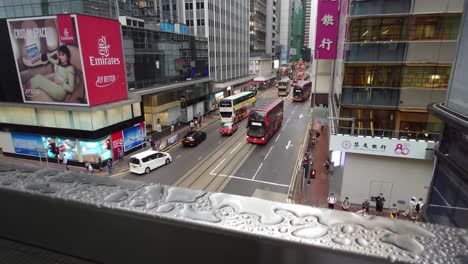 Double-decker-buses-passing-over-Central-Market-through-Des-Voeux-Road-during-summer-evening-in-Hong-Kong,-China