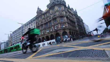 Historic-Edinburgh-street-view-with-old-buildings,-tram,-and-people-on-a-foggy-day