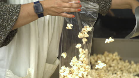 Woman-Putting-Kettlecorn-Into-Plastic-Bag,-50th-Annual-Dogwood-Festival-In-Siloam-Springs,-AR,-USA---Slow-Motion,-Close-Up